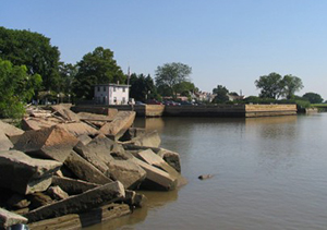 New Castle Harbor. A crumbling ice pier can be seen in the left foreground.  The old ferry dock can be seen in the center background.  The tumbled stone in the left foreground is the remains of an ice pier, one of seven still visible above water. 