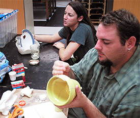 Colleen Reese and Jake Shidner working on reconstructing their broken ceramics to their former glory.