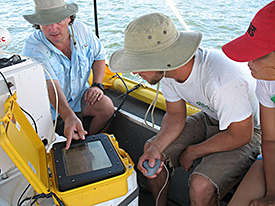Greg showing students side-scan sonar equipment.
