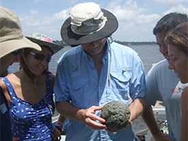 Dr. Bratten and students observing the spherical coral ballast that was found in the amidships unit on Thursday.