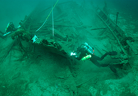 Divers examining wreckage and recording the stempost at the bow.