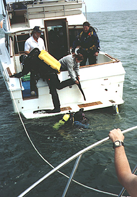 David VanZandt (left, hat) and Kevin Magee (standing, right) assist divers during the survey of the barge Craftsman (Photo by Maritime Archaeological Survey Team, MAST).