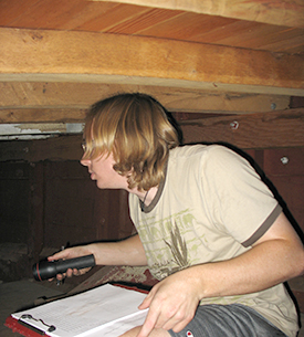 Graduate student Mark Opdyke peers into the dark aboard the Joy Parks to record construction details.