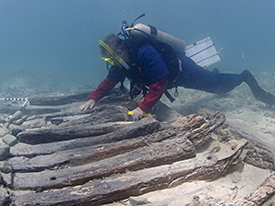 Archaeologist examines articulate structure on the South site.