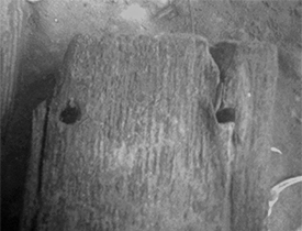 The two holes on this wooden timber show evidence of fasteners, and help archaeologists understand how the vessel was constructed