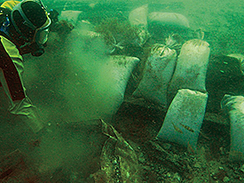 Diver covering the bowcastle in sandbags.