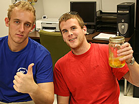 Students Ben Kost and David Ludwig present an acetone rosin solution they prepared to conserve archaeological wood from EP II.