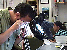 UWFs Dr. John Worth inspecting a glass bead fragment found on EPII this summer.