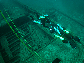 Two divers using trimix gases for longer dive times at great depth. Note the array of tanks required.